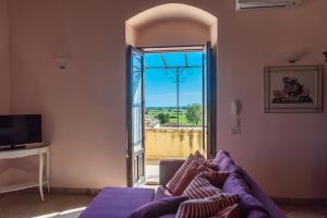 ein Wohnzimmer mit einem Sofa und einem großen Fenster in der Unterkunft Torre Don Virgilio Country Hotel in Cannizzara