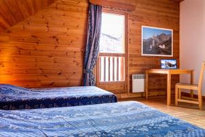 a bedroom with two beds and a window at Le Pignotto Hameau des Chazals Nevache Hautes Alpes in Névache