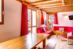 a living room with red furniture and a wooden table at Le Pignotto Hameau des Chazals Nevache Hautes Alpes in Névache