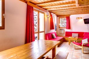 un soggiorno con mobili rossi e tavolo in legno di Le Pignotto Hameau des Chazals Nevache Hautes Alpes a Névache