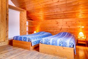 a bedroom with two beds in a log cabin at Le Pignotto Hameau des Chazals Nevache Hautes Alpes in Névache