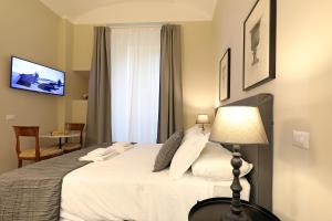 ein Schlafzimmer mit einem Bett mit einer Lampe und einem Fenster in der Unterkunft RESIDENZA VITTORIA Roma in Rom