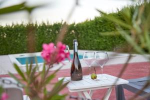 Una botella de vino y dos copas en una mesa. en Agriturismo Da Rosy en Codevigo