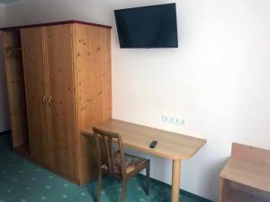 a wooden desk with a chair next to a cabinet at Gasthof Birgl in Inning