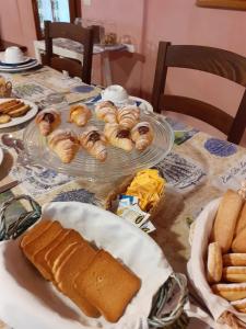 una mesa cubierta con platos de pan y bollería en La Collina dei Passeri en Pocapaglia