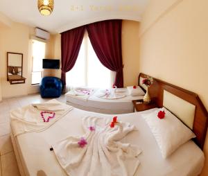 two beds in a hotel room with flowers on them at Palmen Apart Hotel in Alanya