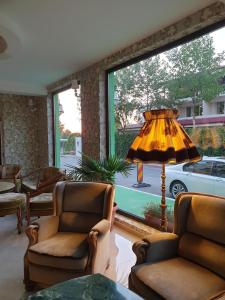 una sala de estar con 2 sillas y una lámpara. en Hotel Atlantic Costinesti, en Costinesti