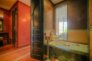 a bathroom with a large mirror and a tub at Tikida Golf Palace - Relais & Châteaux in Agadir
