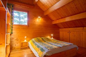 1 dormitorio con 1 cama en una cabaña de madera en L'Elva Hameau des Chazals Nevache Hautes Alpes, en Névache