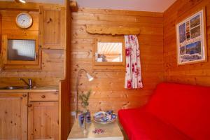 a room with a red bed in a log cabin at L'Elva Hameau des Chazals Nevache Hautes Alpes in Névache