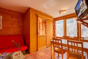 sala de estar con sofá rojo y mesa en L'Elva Hameau des Chazals Nevache Hautes Alpes, en Névache