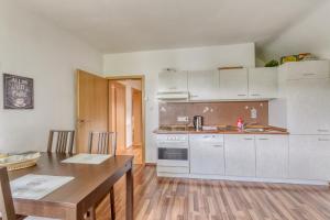 cocina con armarios blancos y mesa de madera en Ferienwohnung in Maring-Noviand en Maring-Noviand