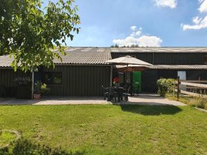 een patio met een tafel en een parasol bij B&B de Rekkendonken in Liempde