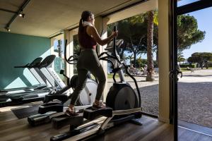a woman running on a treadmill in a gym at Pestana D. João II Beach & Golf Resort in Alvor