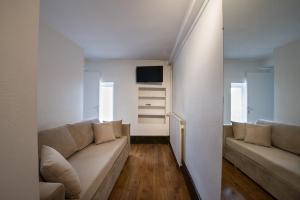un salon avec un canapé et une télévision dans l'établissement Hôtel des Tonneliers, à Beaune