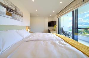 ein Schlafzimmer mit einem weißen Bett und einem großen Fenster in der Unterkunft Villa Dama in Dobrinj