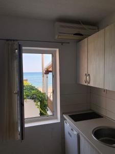 a kitchen with a window with a view of the ocean at Apartments Boss in Budva
