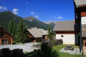 een groep gebouwen met bergen op de achtergrond bij Le Taquo Hameau des Chazals Nevache Hautes Alpes in Névache