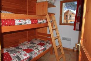 Le Taquo Hameau des Chazals Nevache Hautes Alpes في نافاشي: غرفة نوم مع سريرين بطابقين في كابينة
