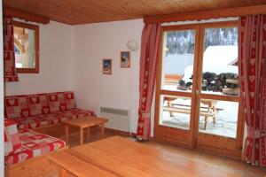 Le Taquo Hameau des Chazals Nevache Hautes Alpes في نافاشي: غرفة معيشة مع أريكة وباب زجاجي