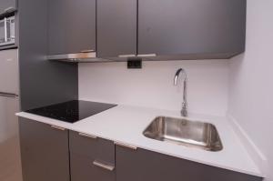 a kitchen with a stainless steel sink and black cabinets at APARTAMENTOS LLAMIEVA in Posada de Llanes +55 photos