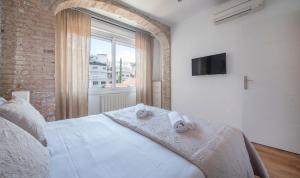バルセロナにあるYou Stylish Diagonal Apartmentsのベッドルーム1室(白いベッド1台、タオル付)