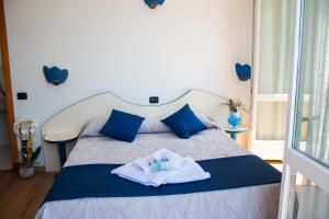 a bed with blue and white towels on it at Hotel Torre Imperiale in Maccagno Superiore