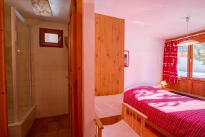 a small bedroom with a bed and a shower at Le Baoùba Hameau des Chazals Nevache Hautes Alpes in Névache