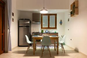 a kitchen with a table and chairs and a refrigerator at La Rotonda - Casa vacanze in Giovinazzo