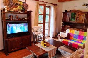 a living room with a tv and a couch at Klimatyczna Willa w stylu BOHO in Wysokie Mazowieckie