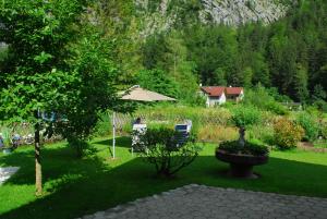 un jardín con sombrilla y sillas y una casa en Ferienwohnung bon WAB, en Hallstatt