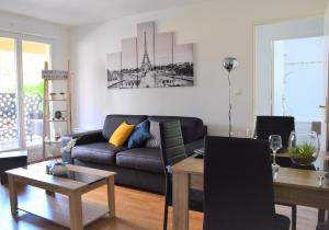 sala de estar con sofá y mesa en Dream Appartement Paris, en Montévrain