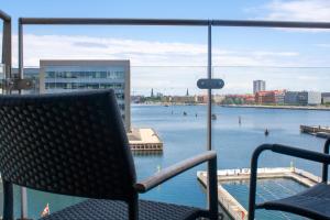 Blick auf einen großen Wasserkörper mit einem Stuhl in der Unterkunft Copenhagen Island Hotel in Kopenhagen