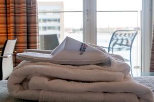 uma pilha de toalhas brancas sentadas em cima de uma mesa em Copenhagen Island Hotel em Copenhague