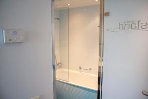 a bathroom with a shower and a bath tub at Copenhagen Island Hotel in Copenhagen