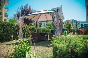 an umbrella in the middle of a garden at Magnolia Garden in Sunny Beach