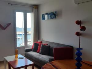 a living room with a couch and a table and a window at Résidence La Grande Voile in Banyuls-sur-Mer