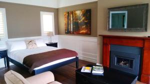 
a living room with a fireplace and a bed at Marysville Garden Cottages in Marysville

