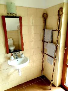 ein Bad mit einem Waschbecken und einem Spiegel in der Unterkunft Klimatyczna Willa w stylu BOHO in Wysokie Mazowieckie