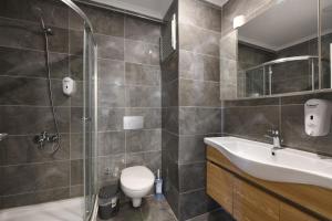 La salle de bains est pourvue de toilettes, d'un lavabo et d'une douche. dans l'établissement Kardeş Suite 4, à Istanbul