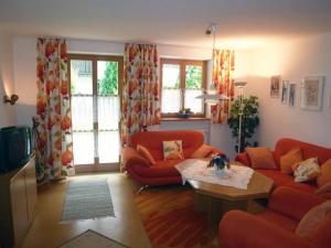 salon z 2 czerwonymi kanapami i stołem w obiekcie Pension an der Linde w mieście Bad Birnbach