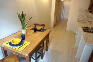 a wooden table with yellow dishes and a plant on it at Lodge San Romano 16 in Lucca