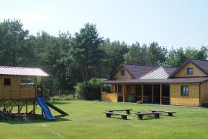 a house with a playground and a house with a slide at Wczasy u Juliana in Drewnica
