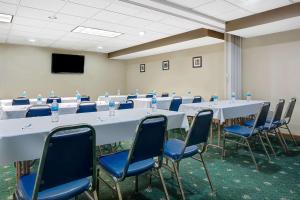 uma sala de conferências com mesas brancas e cadeiras azuis em Travelodge by Wyndham Iowa City em Iowa City
