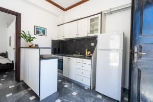 a kitchen with white cabinets and a refrigerator at Hotel Koralli in Kamari