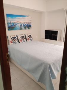 um quarto com uma cama com um quadro na parede em Aldeia das Açoteias em Albufeira