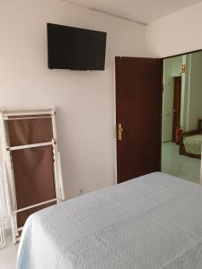 um quarto com uma cama e uma televisão de ecrã plano na parede em Aldeia das Açoteias em Albufeira