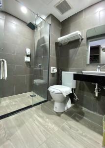 La salle de bains est pourvue de toilettes, d'une douche et d'un lavabo. dans l'établissement Grace Hotel Semporna, à Semporna