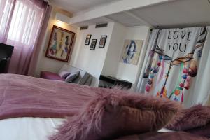 カンヌにあるATH hôtel Athénéeのベッドルーム1室(ベッド1台付)、リビングルーム(ソファ付)