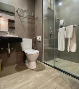 La salle de bains est pourvue de toilettes et d'une douche en verre. dans l'établissement Grace Hotel Semporna, à Semporna